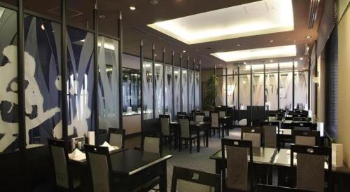 a dining room with tables and chairs in a restaurant at Hotel de Premiere Minowa in Inawashiro