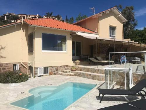 a villa with a swimming pool and a house at Villa Lou Cade, vue imprenable et plage privée, Théoule-sur-mer in Théoule-sur-Mer