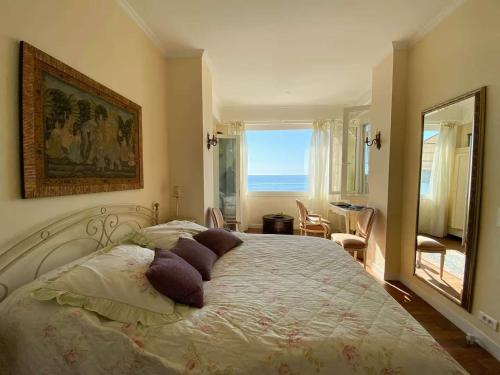 a bedroom with a large bed with pillows on it at Villa Lou Cade, vue imprenable et plage privée, Théoule-sur-mer in Théoule-sur-Mer