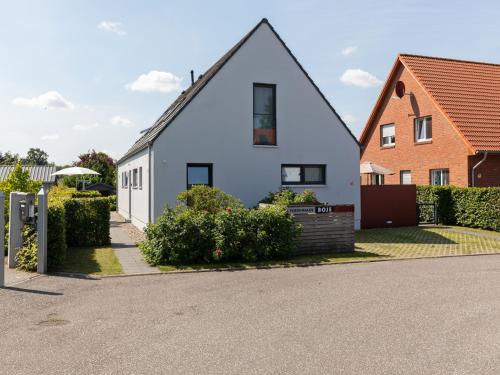 a white house with a red brick house at Pleasant Holiday Home in Zierow near Sea in Zierow