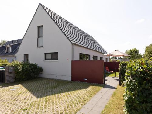 a white house with a black roof at Pleasant Holiday Home in Zierow near Sea in Zierow