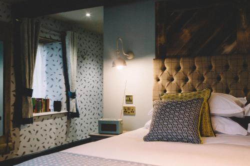 a bedroom with a bed with a wooden headboard at The Stag at Stow in Stow on the Wold
