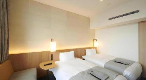 a hotel room with two beds and a couch at HOTEL CLAD in Fuji