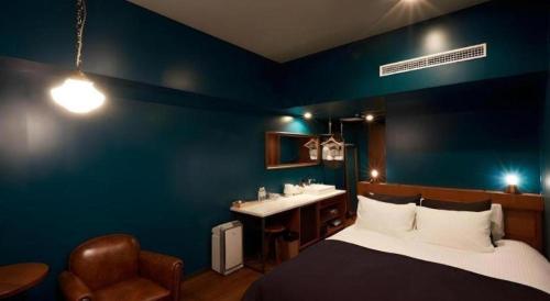 a blue room with a bed and a sink at HOTEL CLAD in Fuji