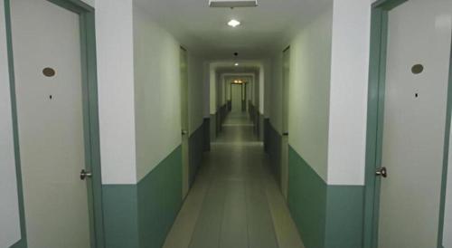 a hallway with green and white walls and doors at Hotel Hung Hung in Kuching
