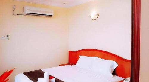 a bedroom with a bed and a air conditioner at Global Hotel Labuan in Labuan