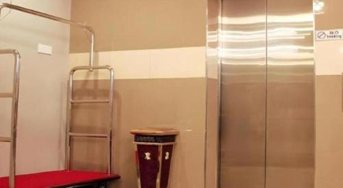a bathroom with a shower and a red stool at Cukai View Hotel in Cukai