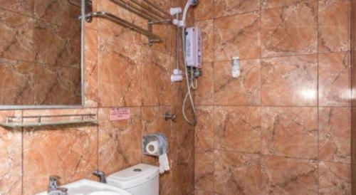 a bathroom with a toilet and a sink and a mirror at OYO 890 Hotel RK Cahaya in Labuan