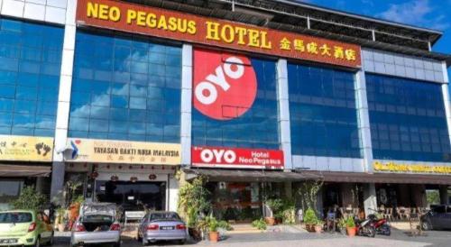 a large building with cars parked in front of it at Super OYO 1114 Neo Pegasus Hotel in Segamat