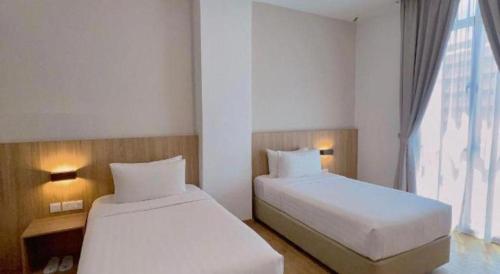 a hotel room with two beds and a window at S Hotel in Johor Bahru