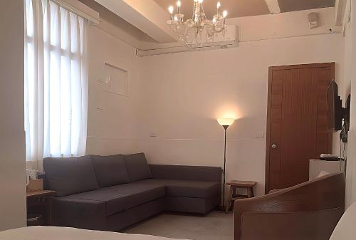 a living room with a couch and a chandelier at 山露露品茶 70年代老房子 二樓背包 4-5樓合併 六人包層 Te en Te' Guesthouse in Tainan