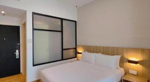 a bedroom with a white bed and a large window at S Hotel in Johor Bahru