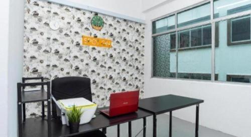an office with a desk with a laptop on it at SPOT ON 89757 The Rooms JB in Johor Bahru