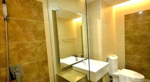 a bathroom with a sink and a toilet and a mirror at Eminent Hotel in Kota Kinabalu
