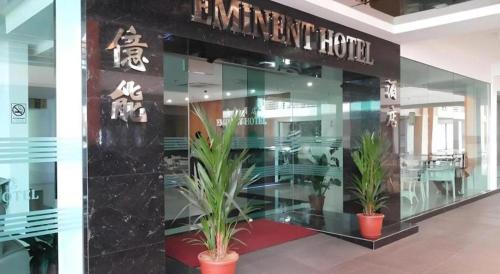 a restaurant with potted plants in front of a building at Eminent Hotel in Kota Kinabalu