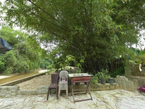 a table and two chairs sitting under a tree at OYO 90642 Twin Mutiara Chalet & Homestay in Jeli