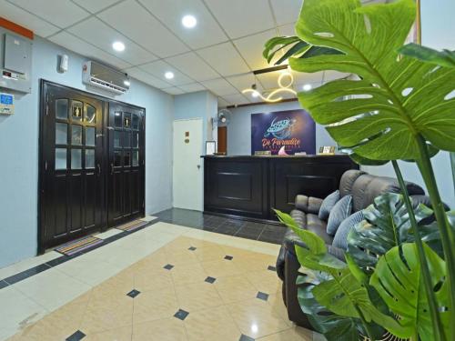 a waiting room with a couch and a television at OYO 90672 De Paradise Turtle Hotel in Kertih