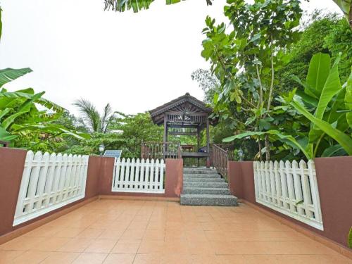 a white fence with a gate and a gazebo at OYO 90642 Twin Mutiara Chalet & Homestay in Jeli