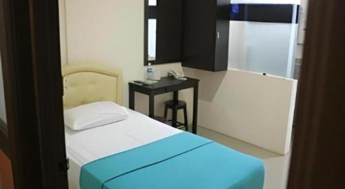 a room with a bed and a table with a phone at Rafayeh Hotel in Seremban