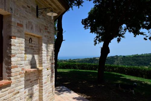 a stone building with a view of a tree at Villa Manu in Lapedona