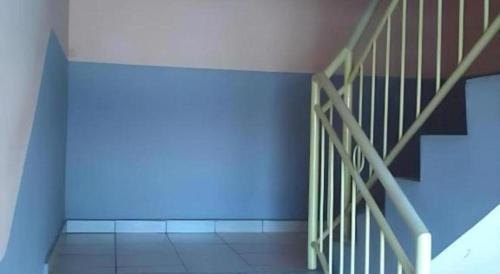 a room with a staircase with a blue wall at OYO 90785 Pandan Hotel in Kota Kinabalu