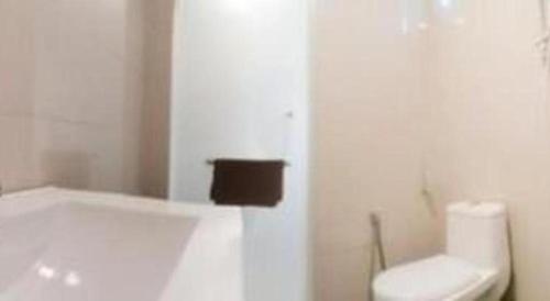 a white bathroom with a toilet and a sink at Rock & Roll Hotel Klang in Klang