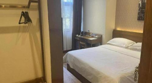 a bedroom with a bed and a bathroom with a sink at James Joyce Coffetel Xian Big Goose Pagoda Tang Paradise Branch in Xi'an