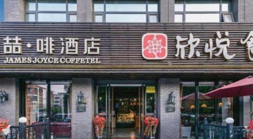a store front of a restaurant with chinese writing on it at James Joyce Coffetel Xian Big Goose Pagoda Tang Paradise Branch in Xi'an