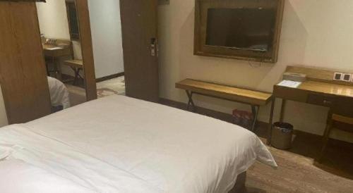a bedroom with a bed and a sink and a mirror at James Joyce Coffetel Xian Big Goose Pagoda Tang Paradise Branch in Xi'an
