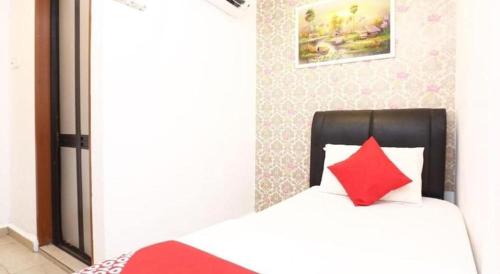 a bedroom with a bed with a red pillow at OYO 718 Mr J Hotel Wakaf Che Yeh 1 in Kota Bharu