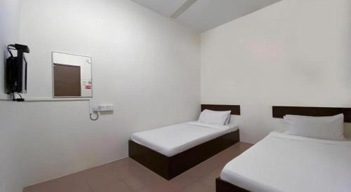 a room with two beds with a mirror and a tv at SPOT ON 91178 Motel Impian in Seri Manjung