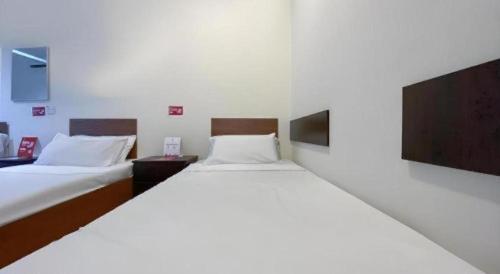 two beds in a room with two beds sidx sidx sidx at SPOT ON 91178 Motel Impian in Seri Manjung
