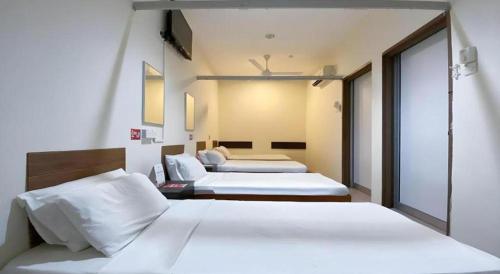 two beds in a hotel room with two beds at SPOT ON 91178 Motel Impian in Seri Manjung