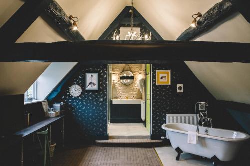 an attic bathroom with a tub and a sink at The Stag at Stow in Stow on the Wold