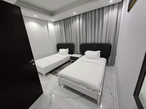 a small room with two beds and a window at Al Safwa One in Al Ḩadd