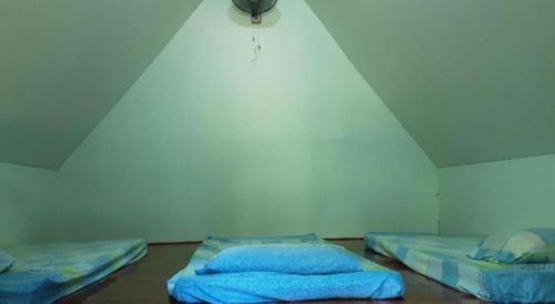 two beds sitting in a room with a light at SPOT ON 90536 Bens Maju Foreststay in Melaka
