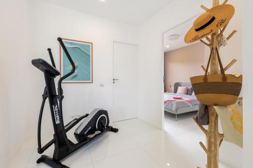 a living room with a treadmill and a bedroom at Villa White Orchid in Choeng Mon Beach
