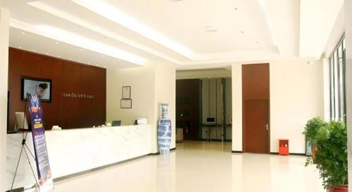 a lobby with a reception desk in a building at City Comfort Inn Qianjiang Longxiacheng in Qianjiang