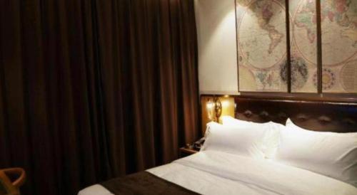 a hotel room with a bed with white sheets at James Joyce Coffetel· Hefei Anhui Agricultural University in Hefei