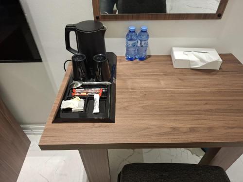 a table with a coffee maker and some water bottles at Al Safwa One in Al Ḩadd
