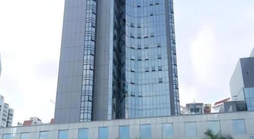 a tall glass building in a city at 7 Days Premium Zhuhai Gongbei Light Railway Branch in Zhuhai