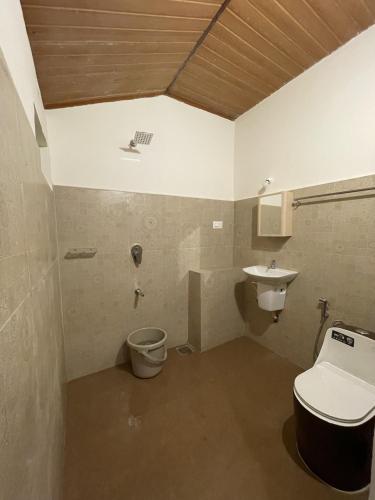 a bathroom with a toilet and a sink at Naad Alaya Estate Stay in Siddapur