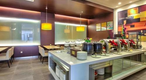 a restaurant with a counter in the middle at Jinjiang Inn Style Xiangshan Bus Station in Xiangshan