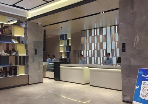 a lobby with people sitting at a reception desk at Echarm Hotel Taizhou International Convention and Exhibition Center 