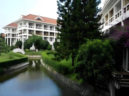 a building next to a river in front of a building at Kunming Dianchi Garden Hotel & Spa in Kunming