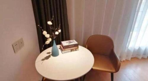 a white table with a chair and a vase on it at Magnotel Shenyang Consulate Qingnian Street in Shenyang