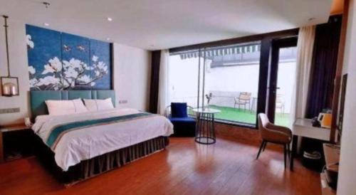 a bedroom with a bed and a table and a window at Magnotel Shenyang Consulate Qingnian Street in Shenyang