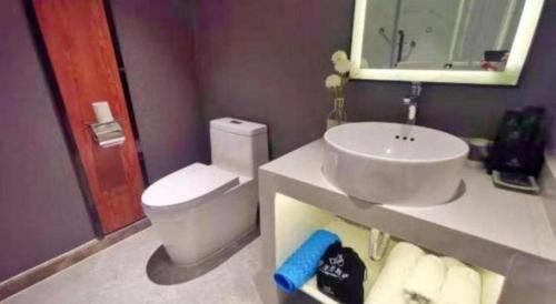 a bathroom with a white toilet and a sink at Magnotel Shenyang Consulate Qingnian Street in Shenyang