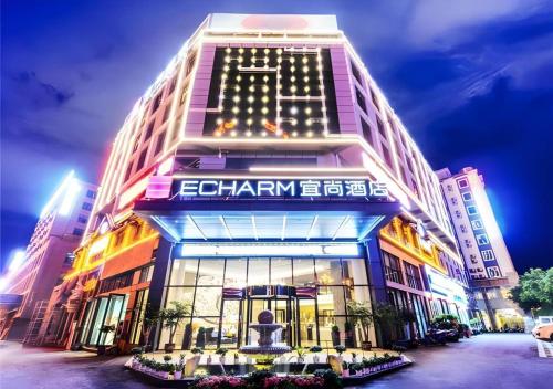 a building with a sign on the front of it at Echarm Hotel Guizhou Xingyi Jushan Avenue in Xiawutun