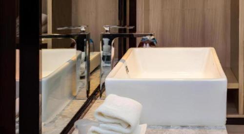 a bathroom with two sinks and a mirror at Echarm Hotel Guizhou Xingyi Jushan Avenue in Xiawutun